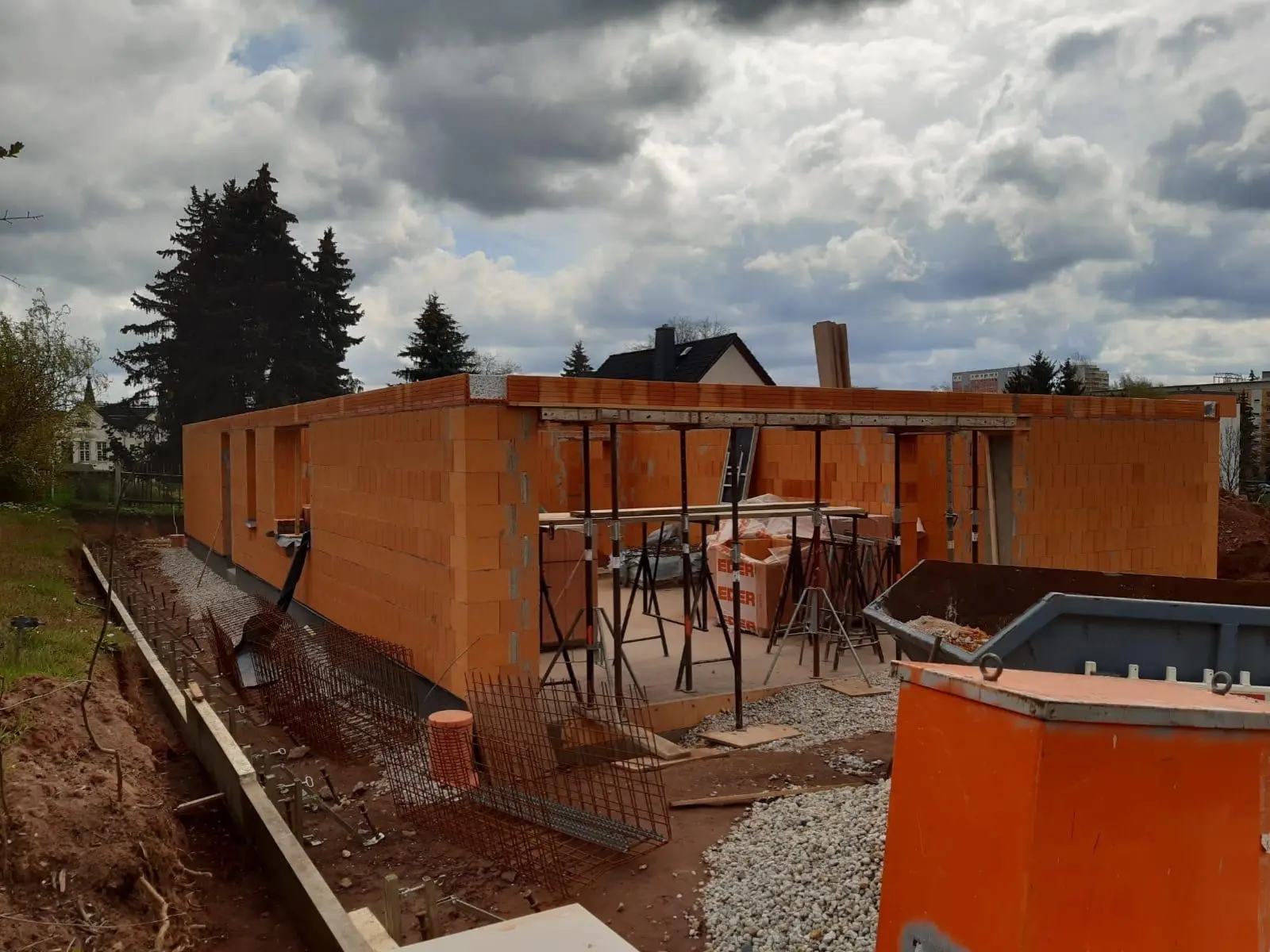 Baustelle mit Bauschild der HS Bau GmbH, Aushub und Bewehrungsstahl