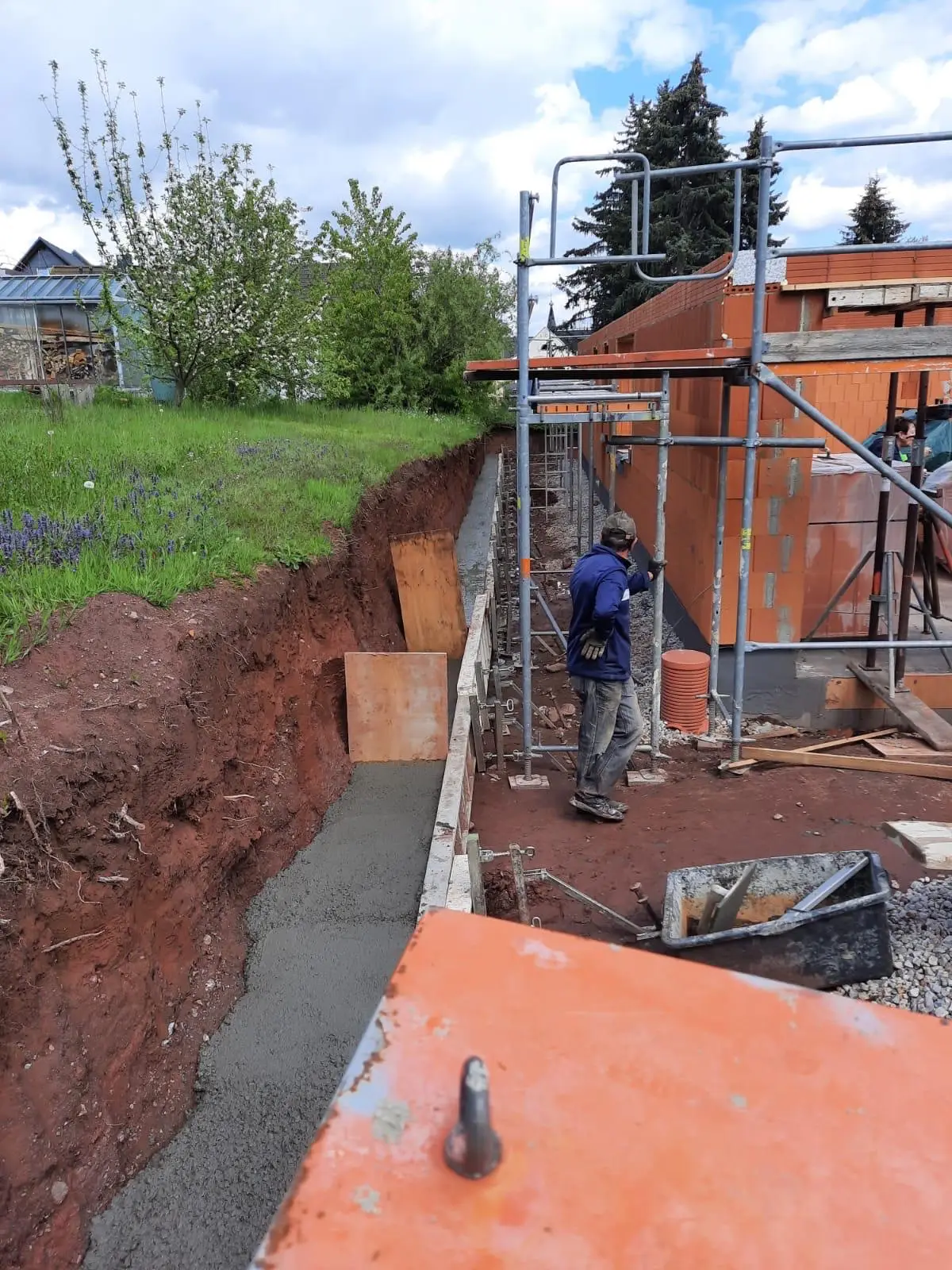 Frisch betoniertes Streifenfundament entlang der Kelleraußenwand